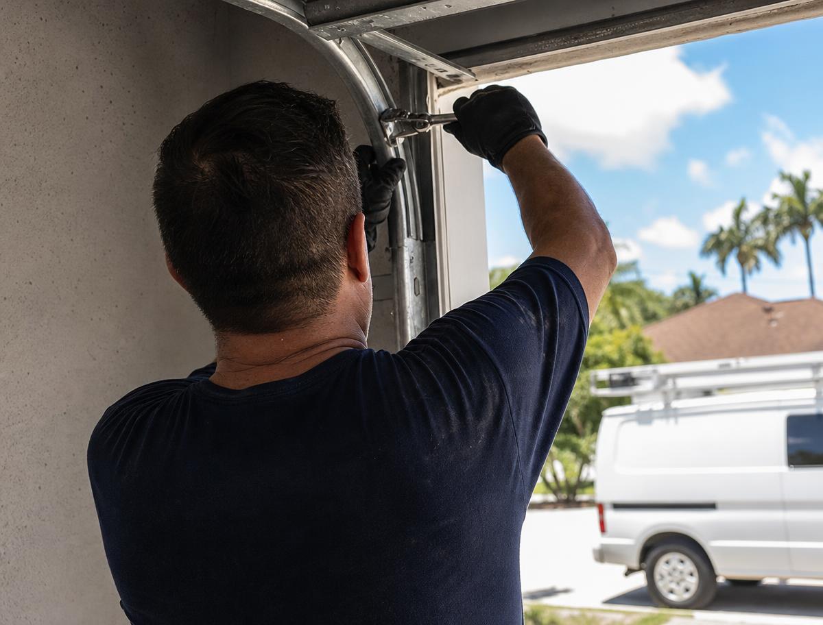 Garage door technician adjusting track hardware on a Fort Myers, Florida home